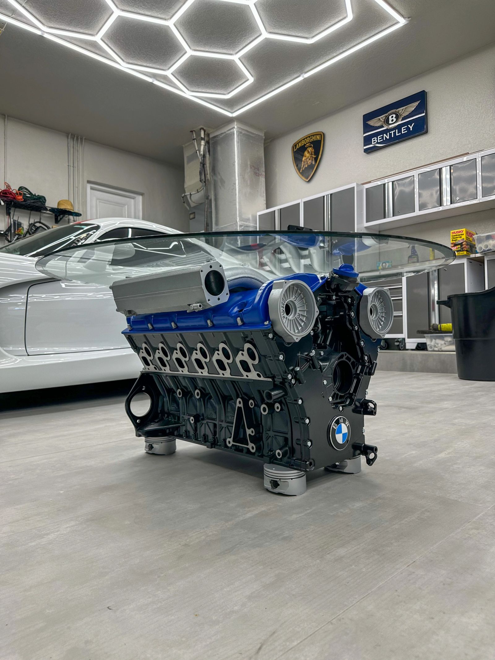 BMW engine table with a black block, blue valve covers and a round glass top