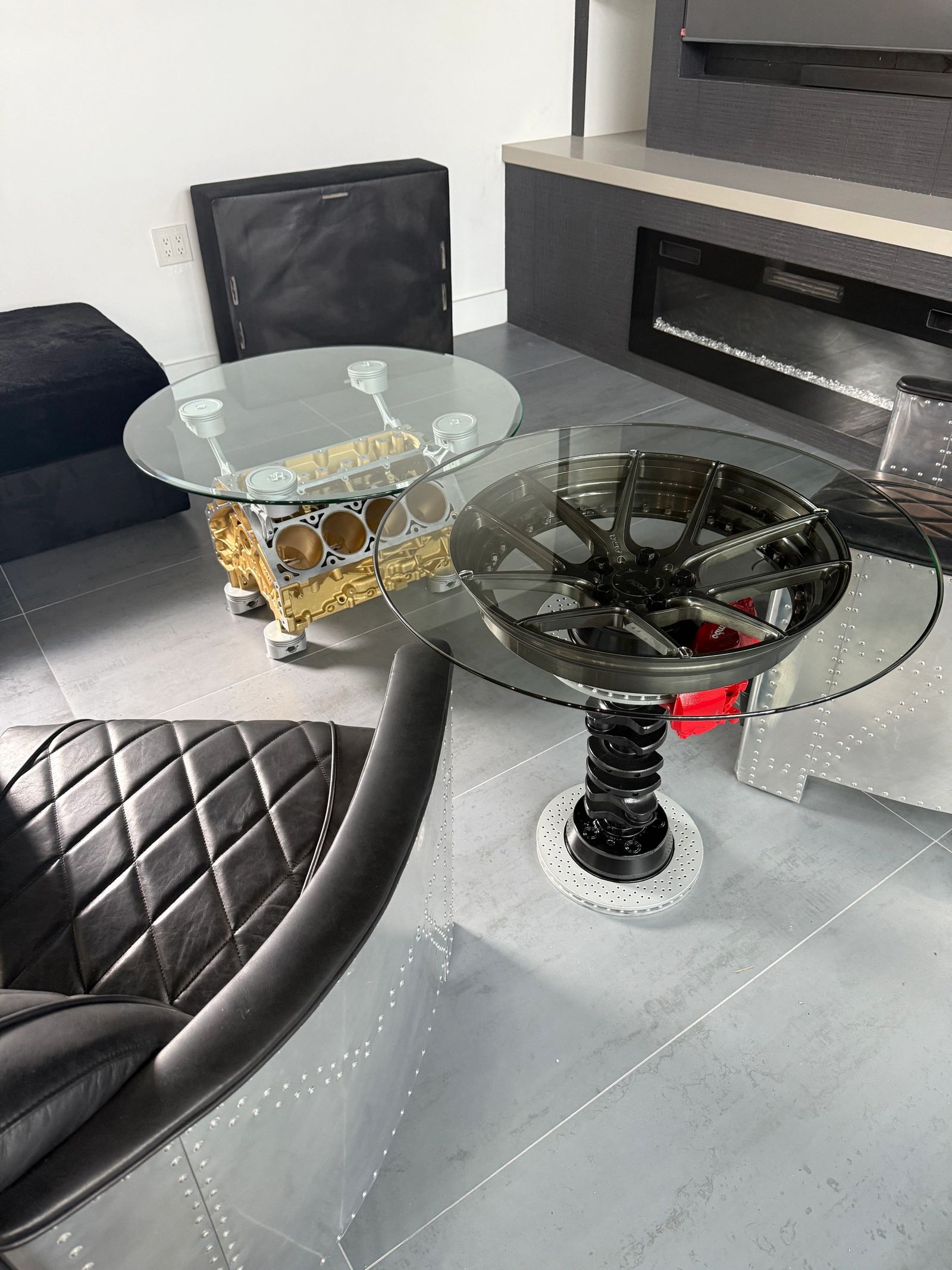Living room with a gold V8 block table and a wheel-and-coilover side table