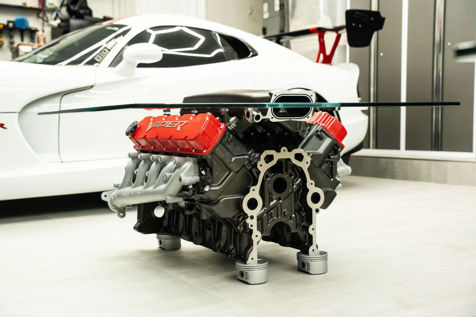 Viper V10 engine table with a black block and red Viper valve covers, on piston feet